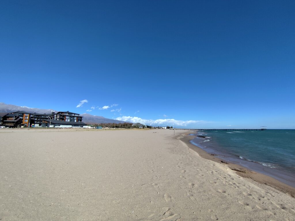 Береговая линия Иссык-Куля и жилой комплекс на заднем плане